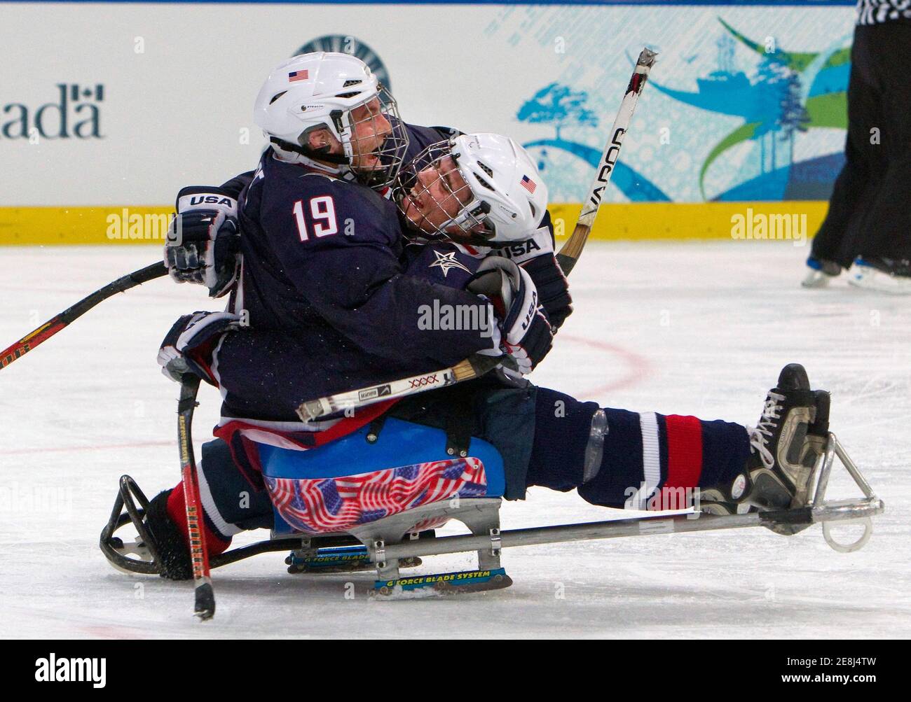 USA's Taylor Chace (L) and Andy Yohe celebrate winning the gold medal sledge hockey game against Japan at the 2010 Paralympic Winter Games in Vancouver, British Columbia, March 20, 2010.       REUTERS/Andy Clark        (CANADA - Tags: SPORT OLYMPICS ICE HOCKEY) Stock Photo