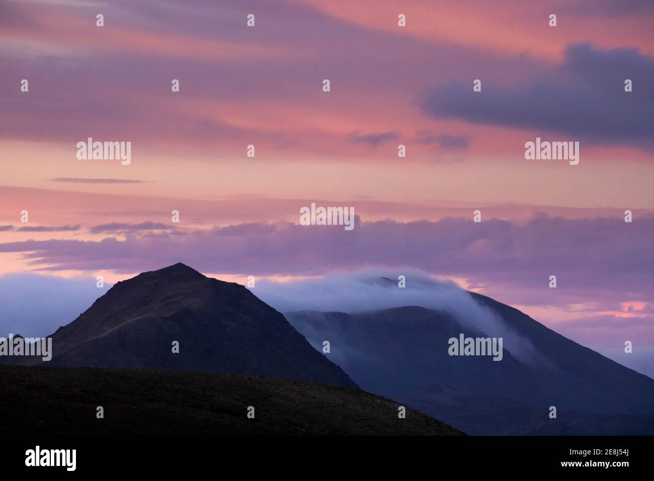 Breathtaking scenery of rocky mountain range with peaks in dense mist ...