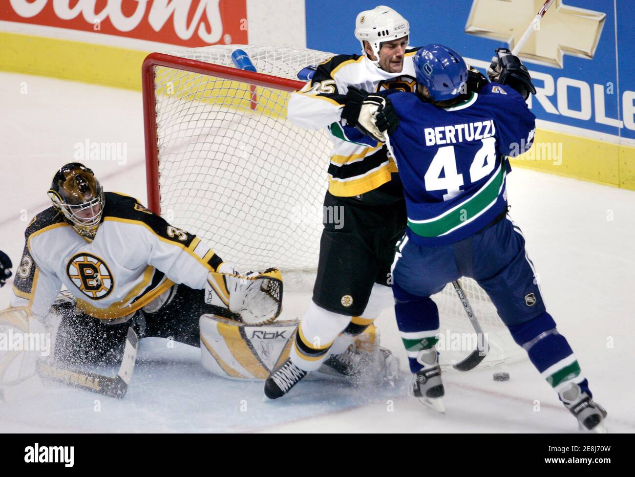 Boston Bruins Hal Gill (C) and Vancouver Canucks Todd Bertuzzi tangle with each other during NHL second period play in Vancouver, British Columbia, December 4, 2005. On the left is Bruins goalie Hannu Toivonsen. REUTERS/Andy Clark Stock Photo