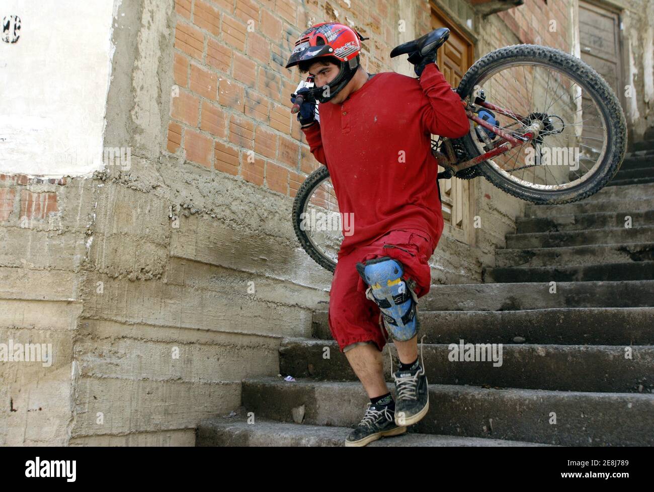 A rider carries his bike during the Red Bull urban assault "Condor's fall"in outskirts of La Paz, Bolivia, November 26, 2005. Extreme mountain bikers of Bolivia, Chile ,Ecuador and U.S.