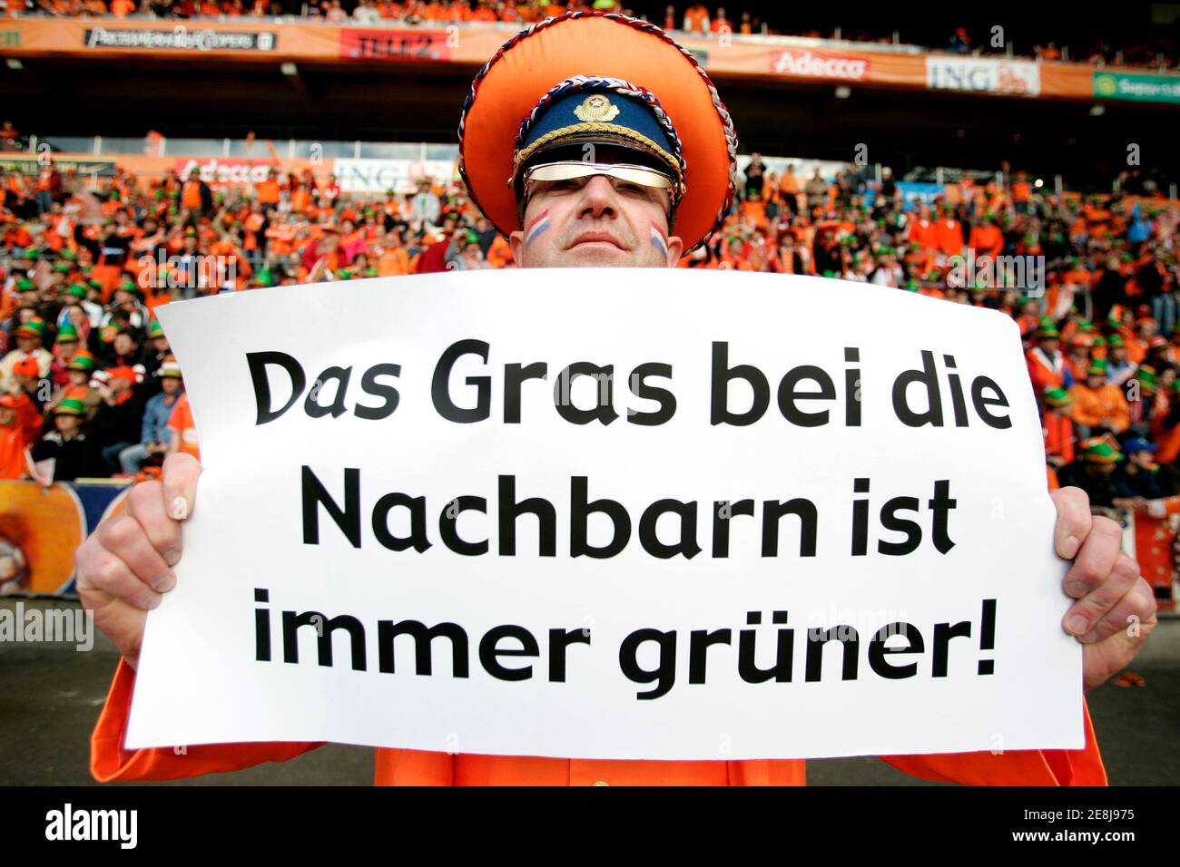 A Netherlands' supporter holds up a placard in Eindhoven June 1, 2006. The placard, which refers to the grass used in the German stadiums for the upcoming 2006 World Cup, reads, 'The grass at the neighbours is always more green'.   WORLD CUP 2006 PREVIEW       REUTERS/Jerry Lampen   (NETHERLANDS) Stock Photo