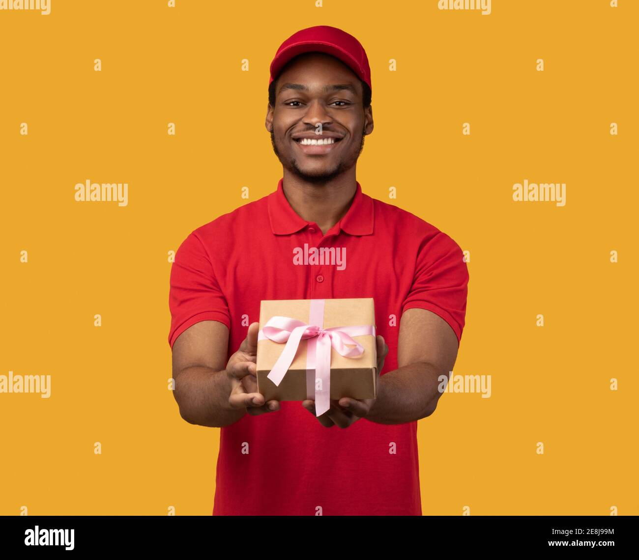 Black delivery guy holding gift box showing to camera Stock Photo