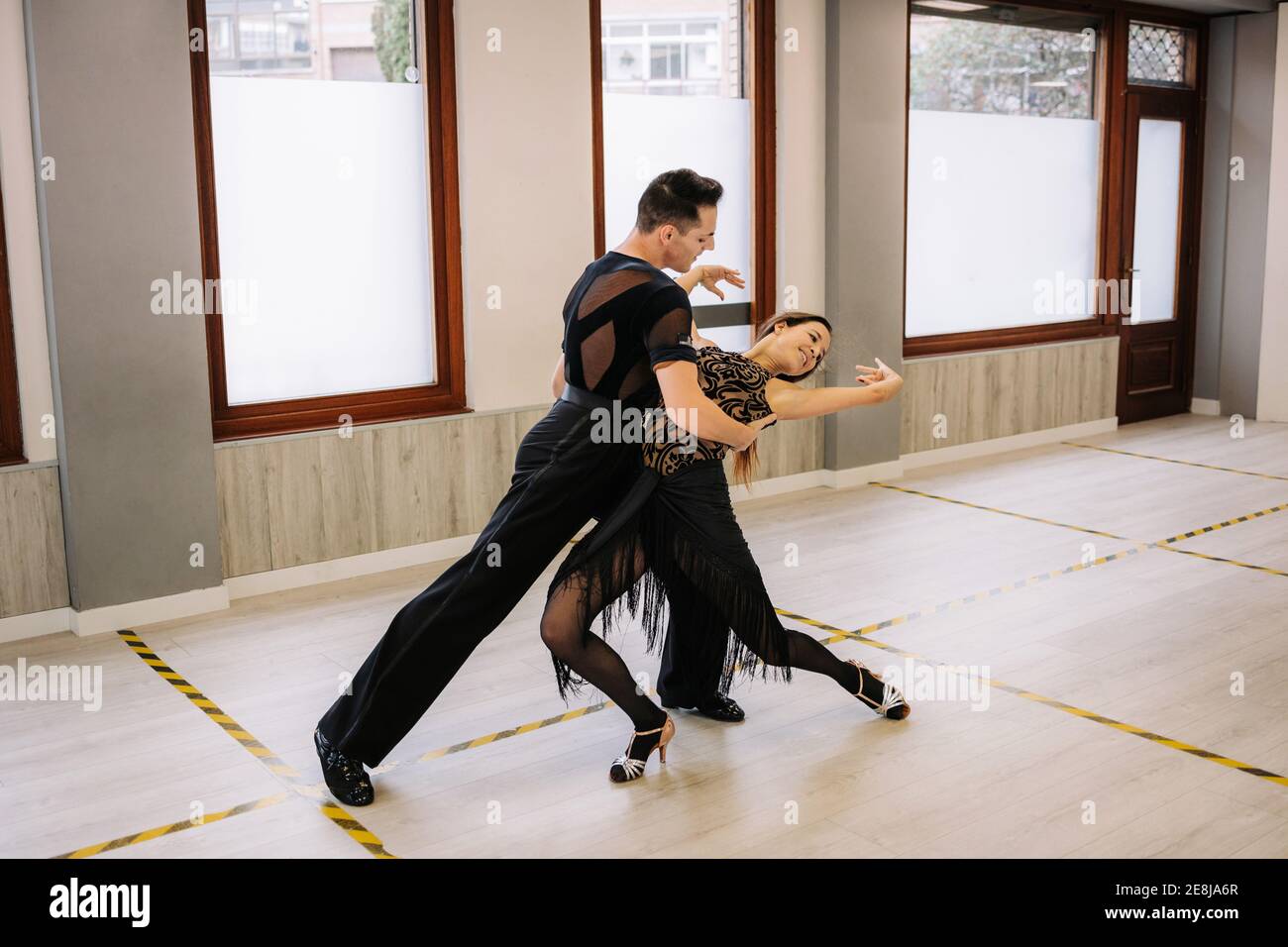 Couple of dancers in elegant wear performing ballroom dance during
