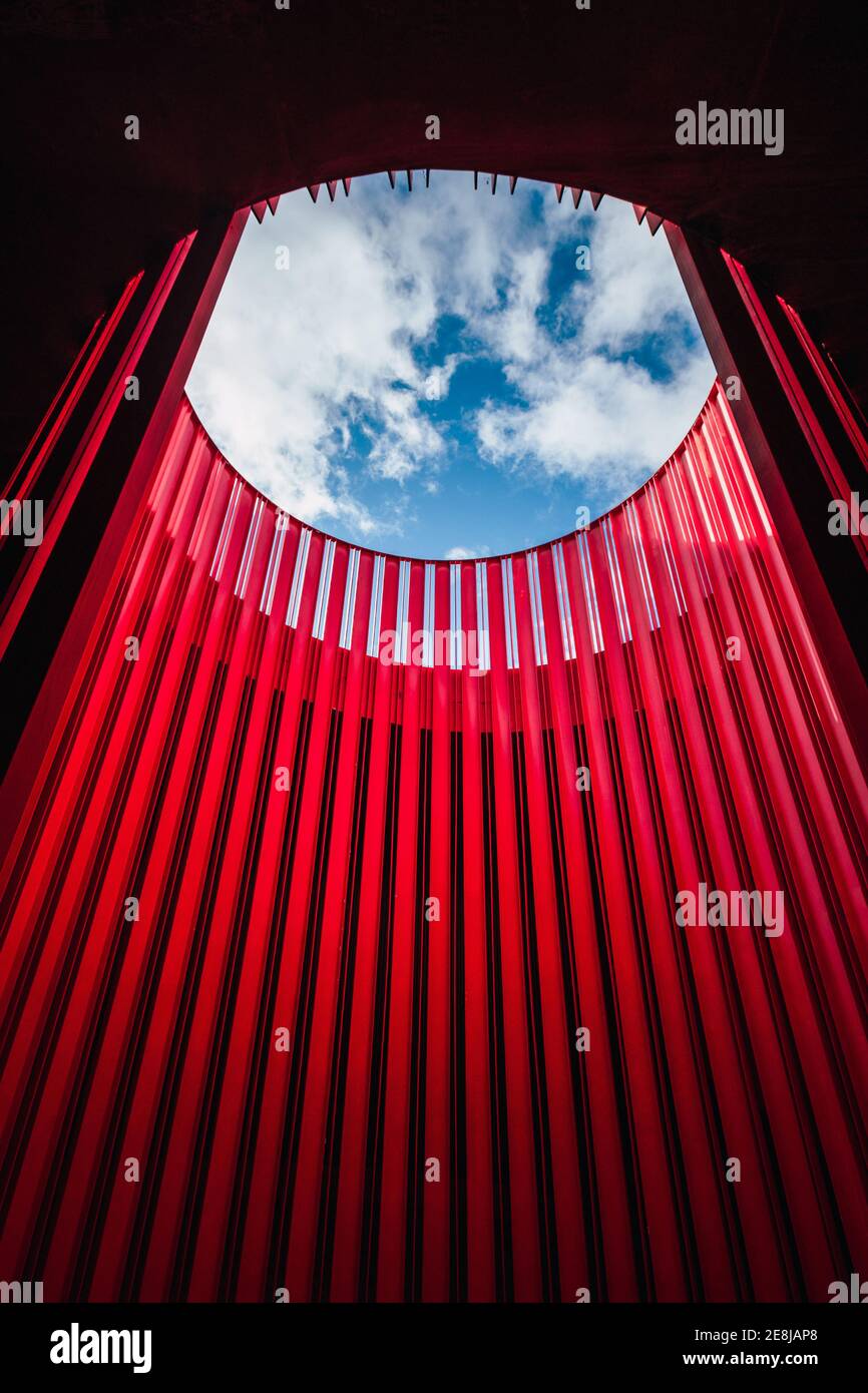 From below of bright round shaped geometric wall under blue sky with ...
