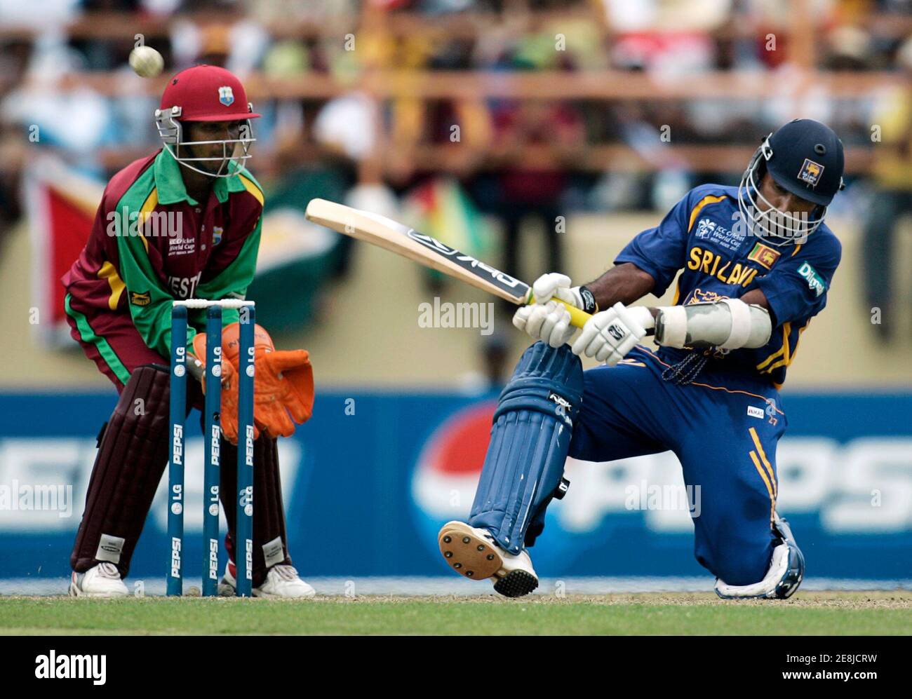 Sri Lanka's captain Mahela Jayawardene plays a shot as West Indies wicketkeeper Denesh Ramdin watches during their World Cup cricket Super Eights match in Georgetown April 1, 2007.   MOBILES OUT, EDITORIAL USE ONLY   REUTERS/Andy Clark   (GUYANA) Stock Photo