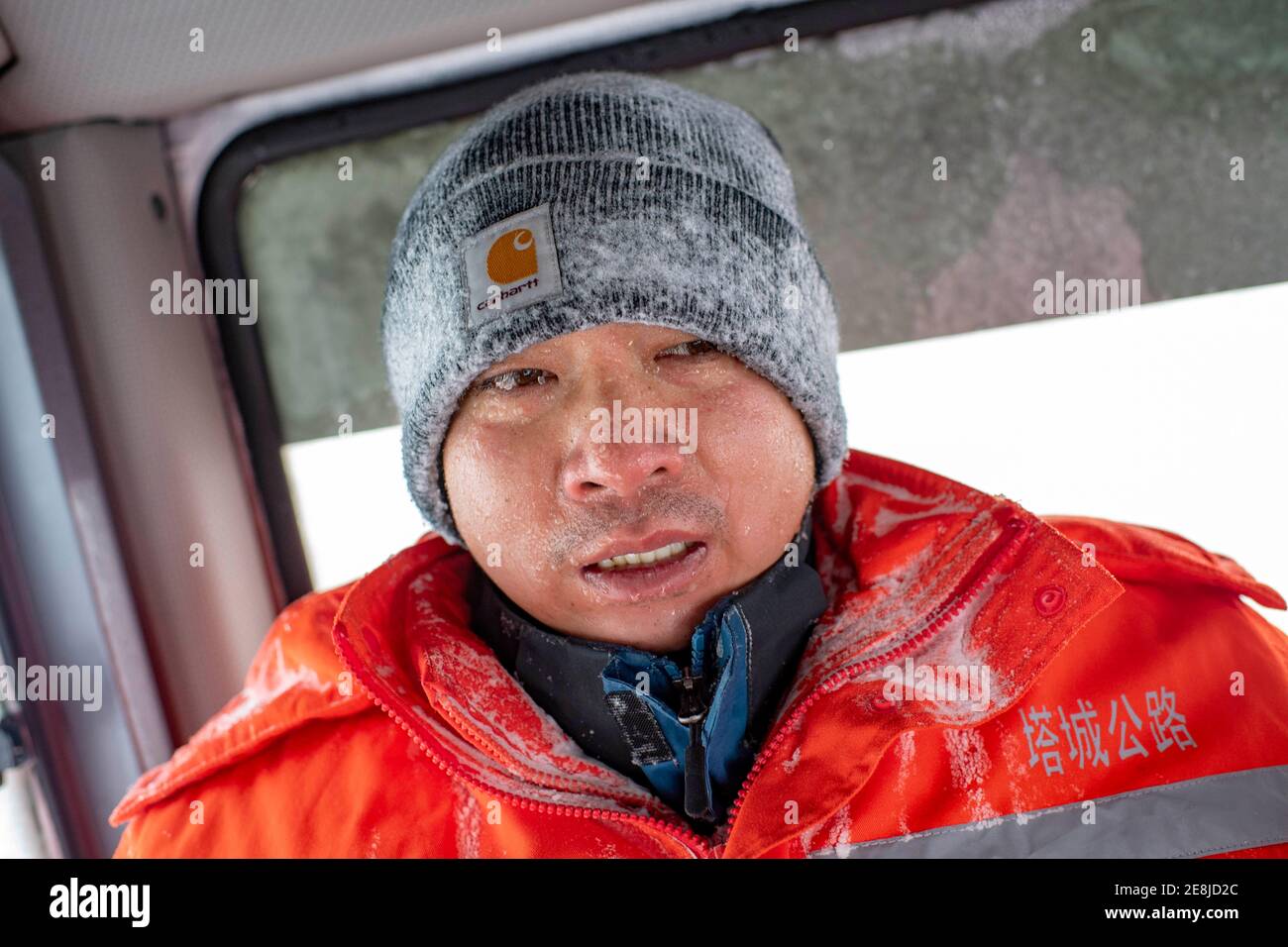 (210131) -- URUMQI, Jan. 31, 2021 (Xinhua) -- A staff member of the Maytas wind prevention and rescuing base returns to the driver's cab to keep warm after searching for stranded passengers in Maytas, Emin County of northwest China's Xinjiang Uygur Autonomous Region, Jan. 23, 2021. Maytas, located in Emin County, is an important thoroughfare with tough weather conditions of snowstorms and heavy wind for about half a year.   Since 2002, the Maytas wind prevention and rescuing base has been responsible for road clearing and rescuing of the S201 in the region. For people who are on duty here, wor Stock Photo