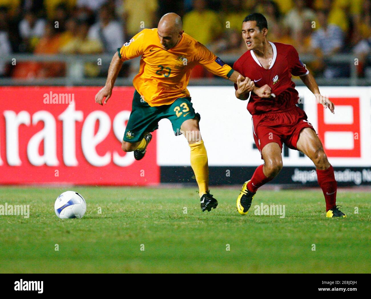 Australia's Mark Bresciano (L) is held by Thailand's Nirut Surasiang while chasing the ball during their AFC Asian Cup tournament Group A match in Bangkok July 16, 2007.     REUTERS/Jerry Lampen  (THAILAND) Stock Photo