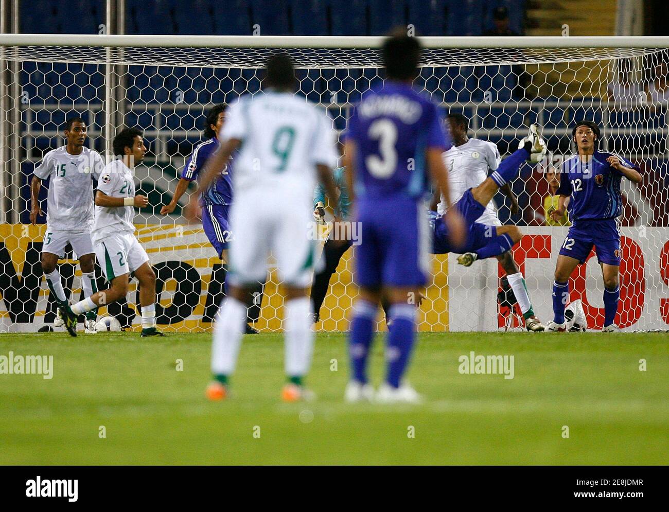 Japan's Yuki Abe (C, partially obscured) kicks to score a goal against Saudi Arabia during their semi-final match at the 2007 AFC Asian Cup soccer tournament at My Dinh Stadium in Hanoi July 25, 2007.  REUTERS/Jerry Lampen (VIETNAM) Stock Photo