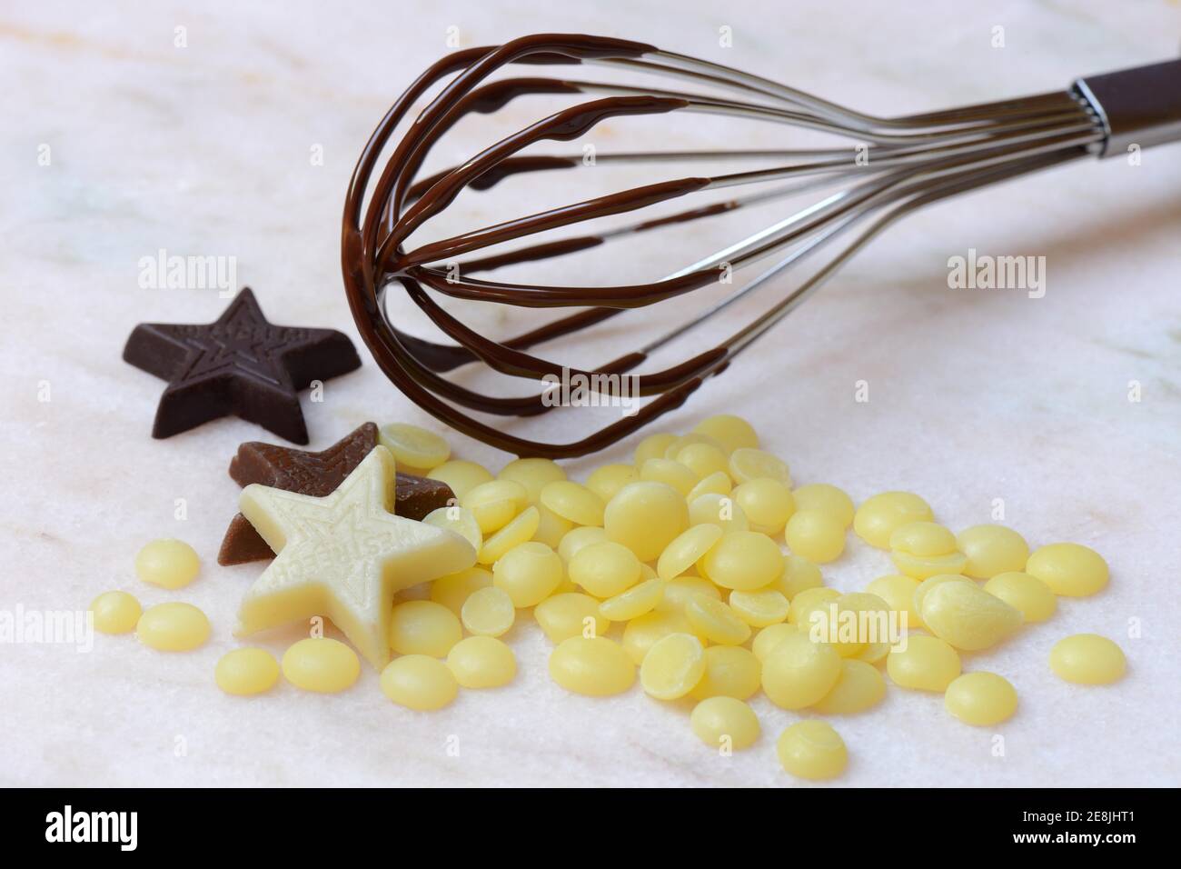 Cocoa butter and chocolate stars with whisk( Theobroma cacao) , cocoa, melted, chocolate ingredient Stock Photo
