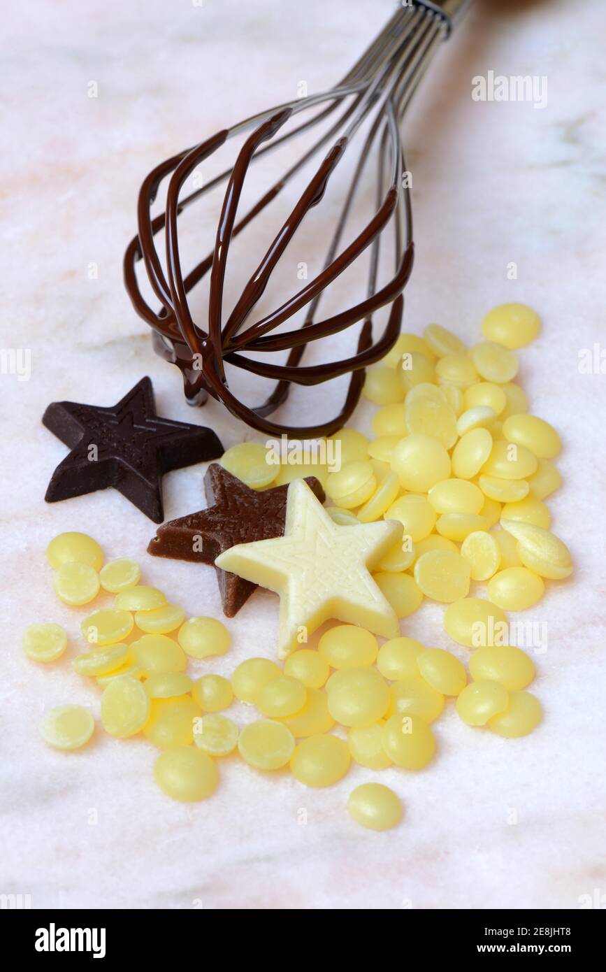 Cocoa butter and chocolate stars with whisk( Theobroma cacao) , cocoa, melted, chocolate ingredient Stock Photo
