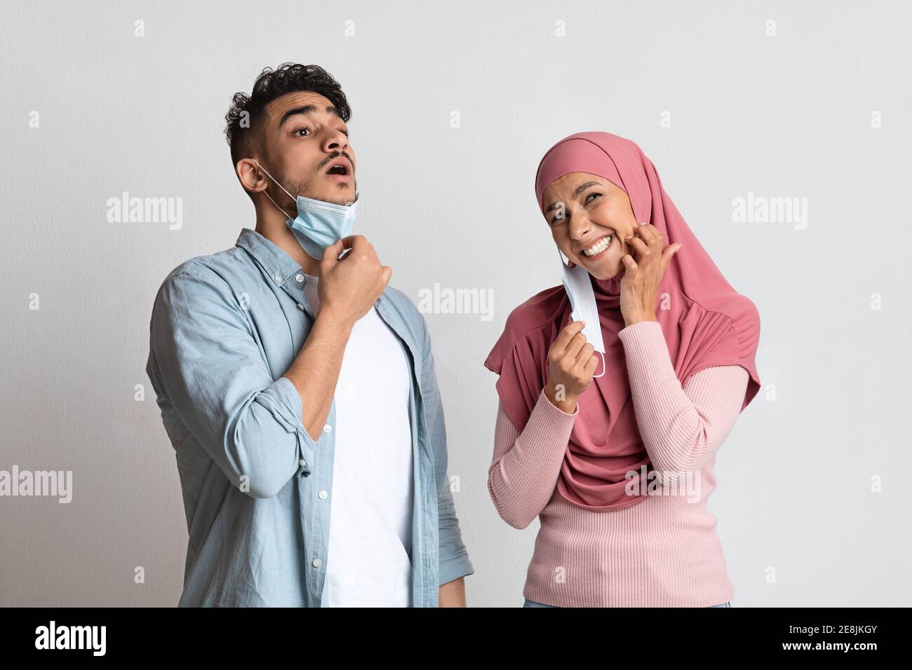 Muslim man and woman feeling discomfort after wearing protective medical face mask Stock Photo