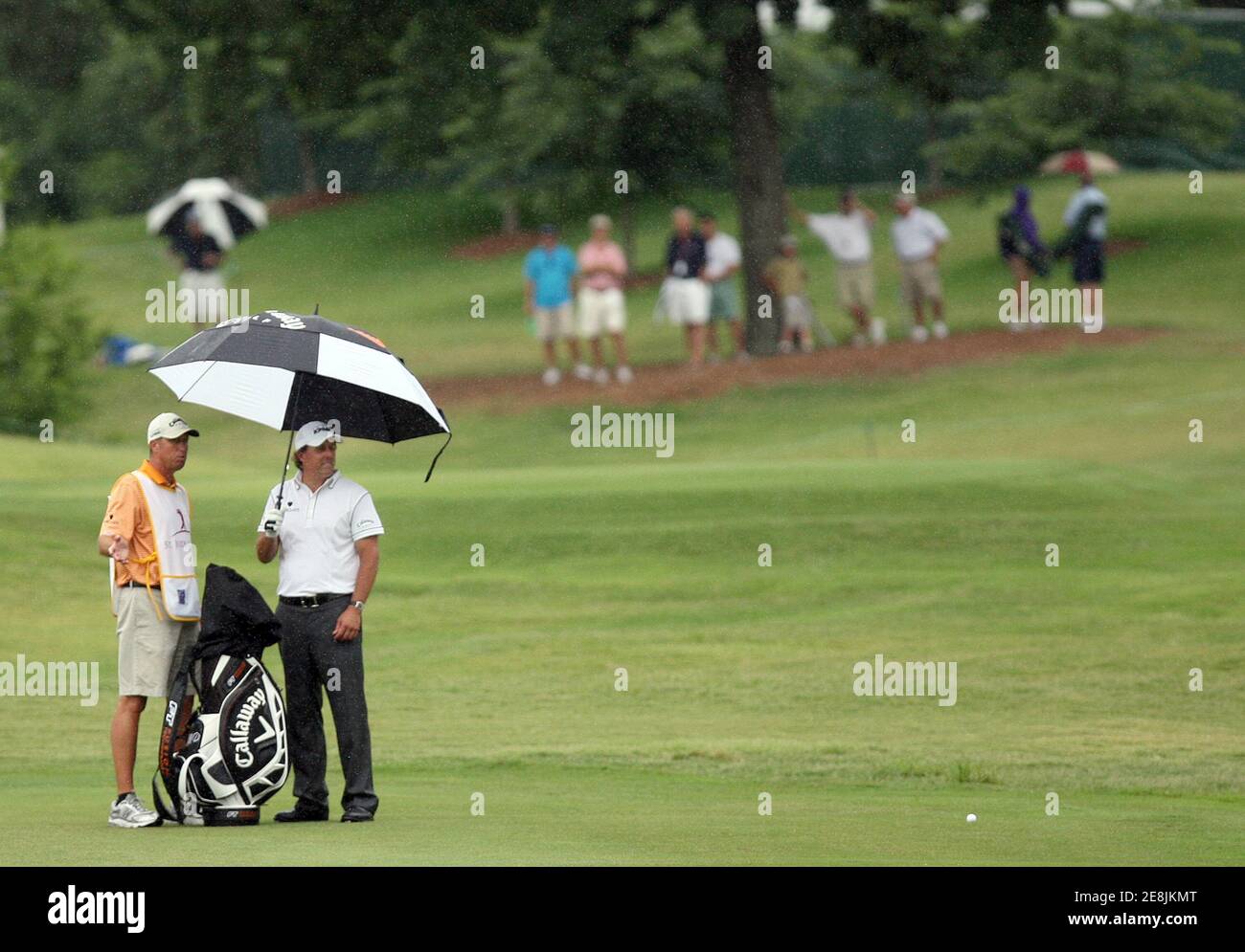 Phil Mickelson, of the U.S., with his caddy Jim Mackay (L), prepares for his shot on the 18th green during the first round of the St. Jude Classic at TPC Southwind in Memphis, Tennessee June 11, 2009.   REUTERS/Nikki Boertman    (UNITED STATES SPORT GOLF) Stock Photo