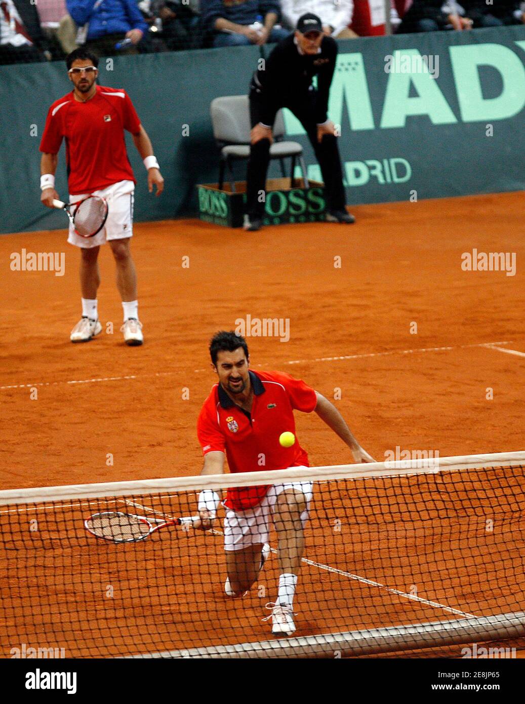 Serbia's Nenad Zimonjic (bottom) and Janko Tipsarevic play against Bob Bryan and John Isner of the U.S. during their Davis Cup World Group, 1st round tennis match in Belgrade March 6, 2010.      REUTERS/Ivan Milutinovic (SERBIA - Tags: SPORT TENNIS) Stock Photo