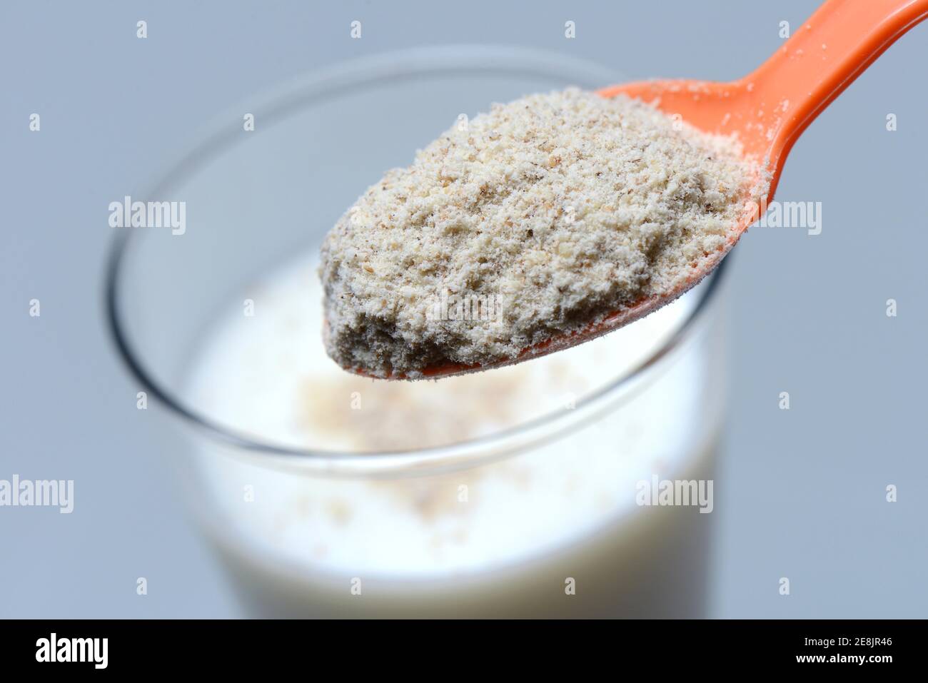 Tigernut flour in spoon and glass of milk, Cyperus esculentus Stock Photo