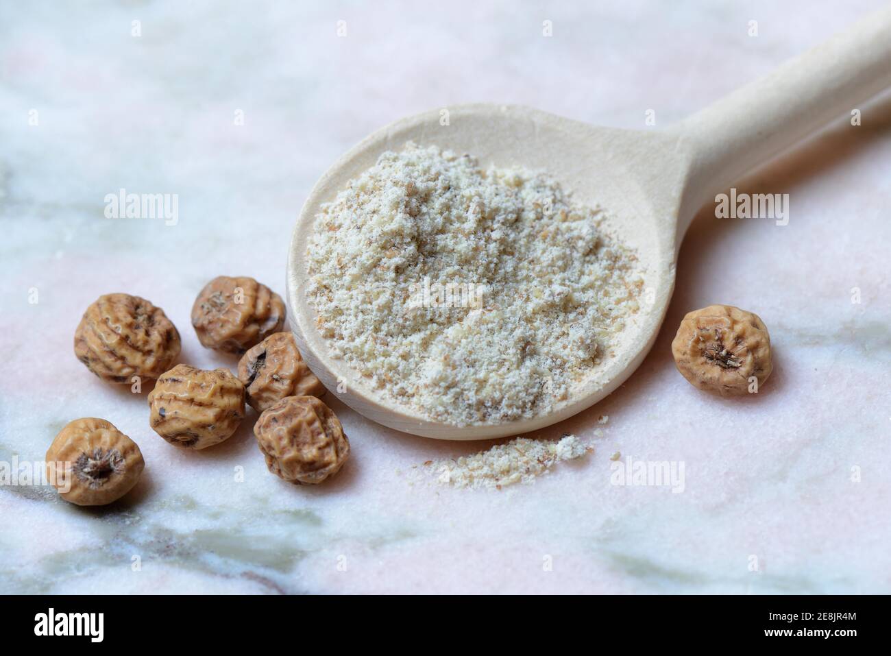 Tigernuts and tigernut flour in cooking spoon, Cyperus esculentus Stock Photo