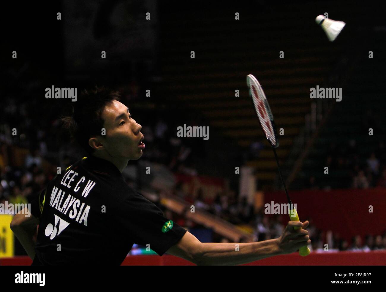 Lee Chong Wei of Malaysia plays a shot to Kenichi Tago of Japan during their men's singles quarter-final match at the Djarum Indonesia Open Super Series badminton tournament in Jakarta June 25, 2010. REUTERS/Beawiharta (INDONESIA - Tags: SPORT BADMINTON) Stock Photo