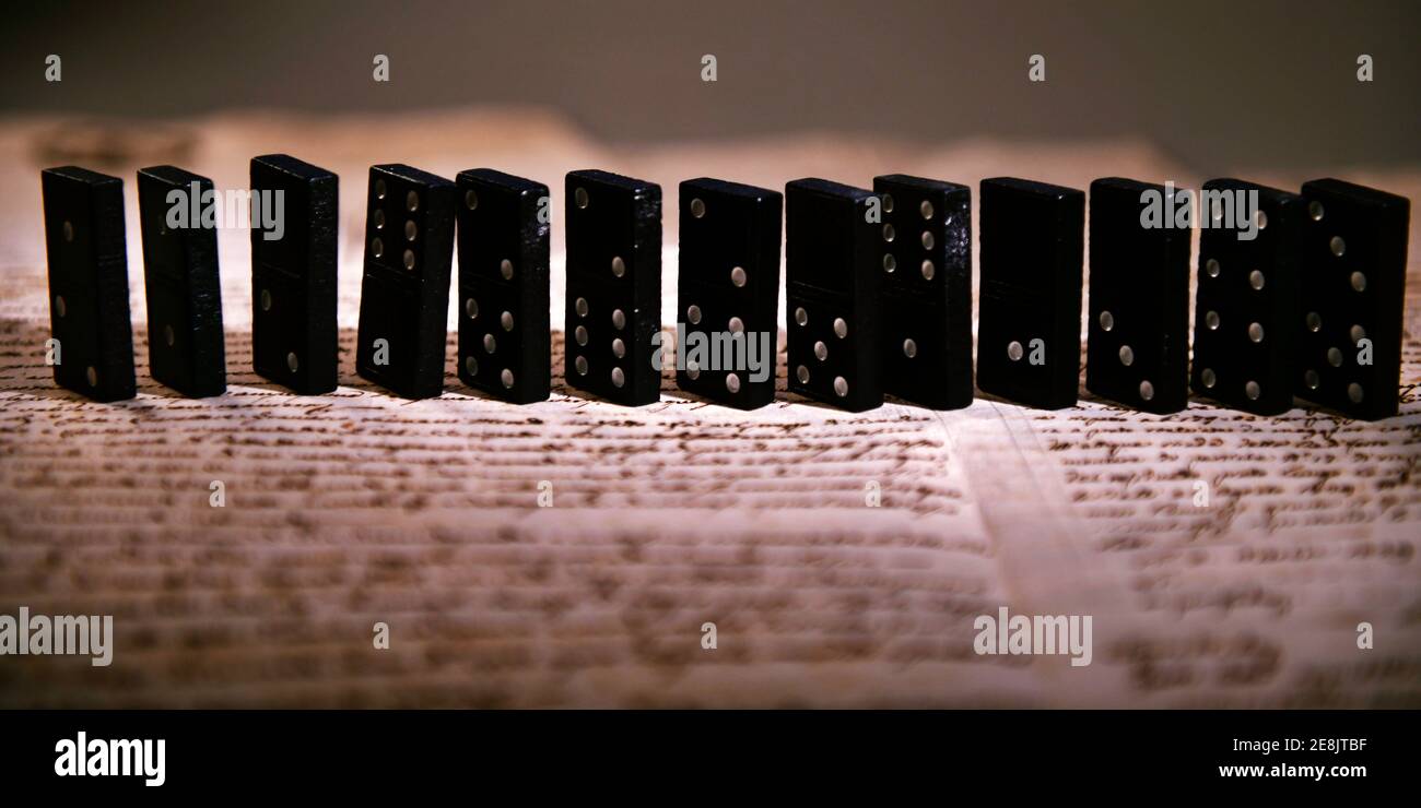 Dominoes on dark background of written pages Stock Photo
