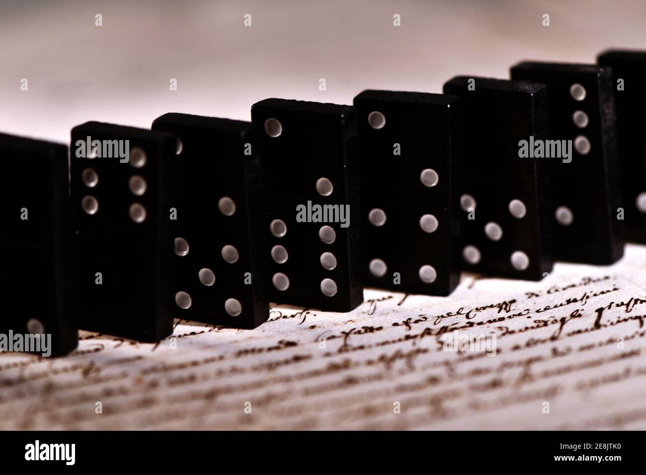 Dominoes on dark background of written pages Stock Photo