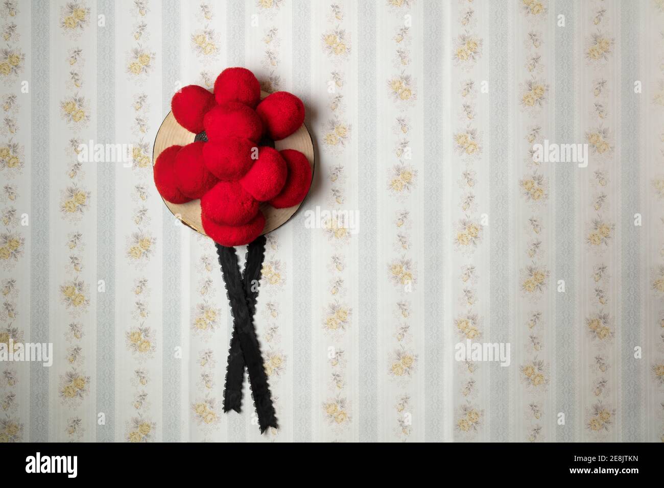 old black forest hat hanging on an old-fashioned wallpaper wall Stock Photo