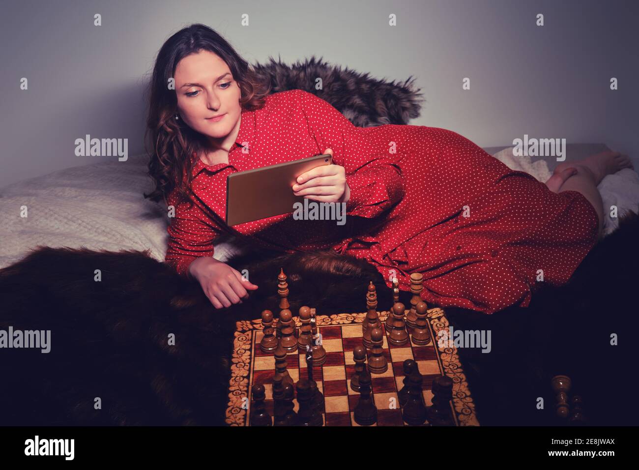 Premium Photo  Woman playing chess online on tablet computer