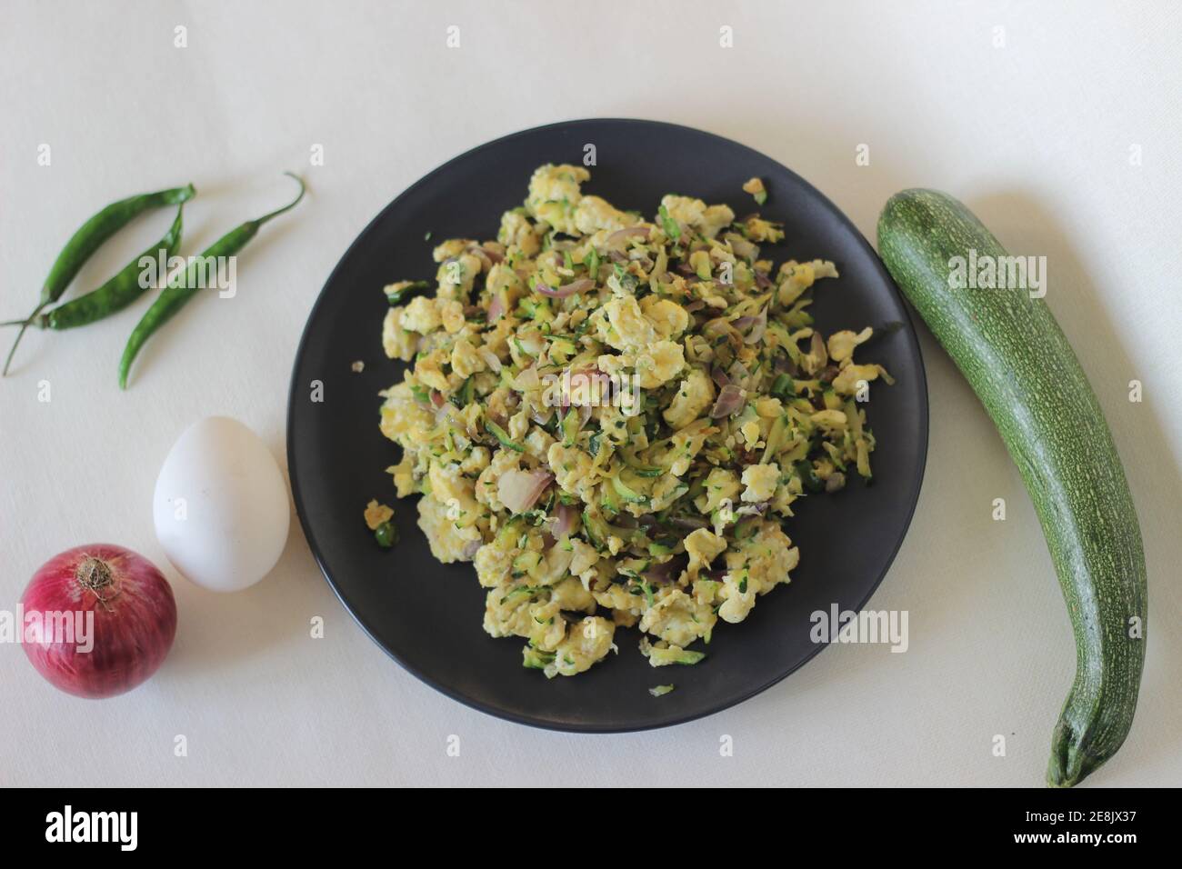 Scrambled Eggs With grated green Zucchini as a healthy breakfast Stock Photo