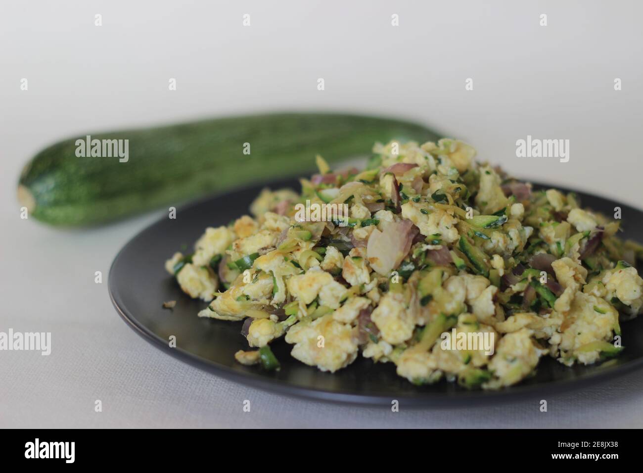 Scrambled Eggs With grated green Zucchini as a healthy breakfast Stock Photo