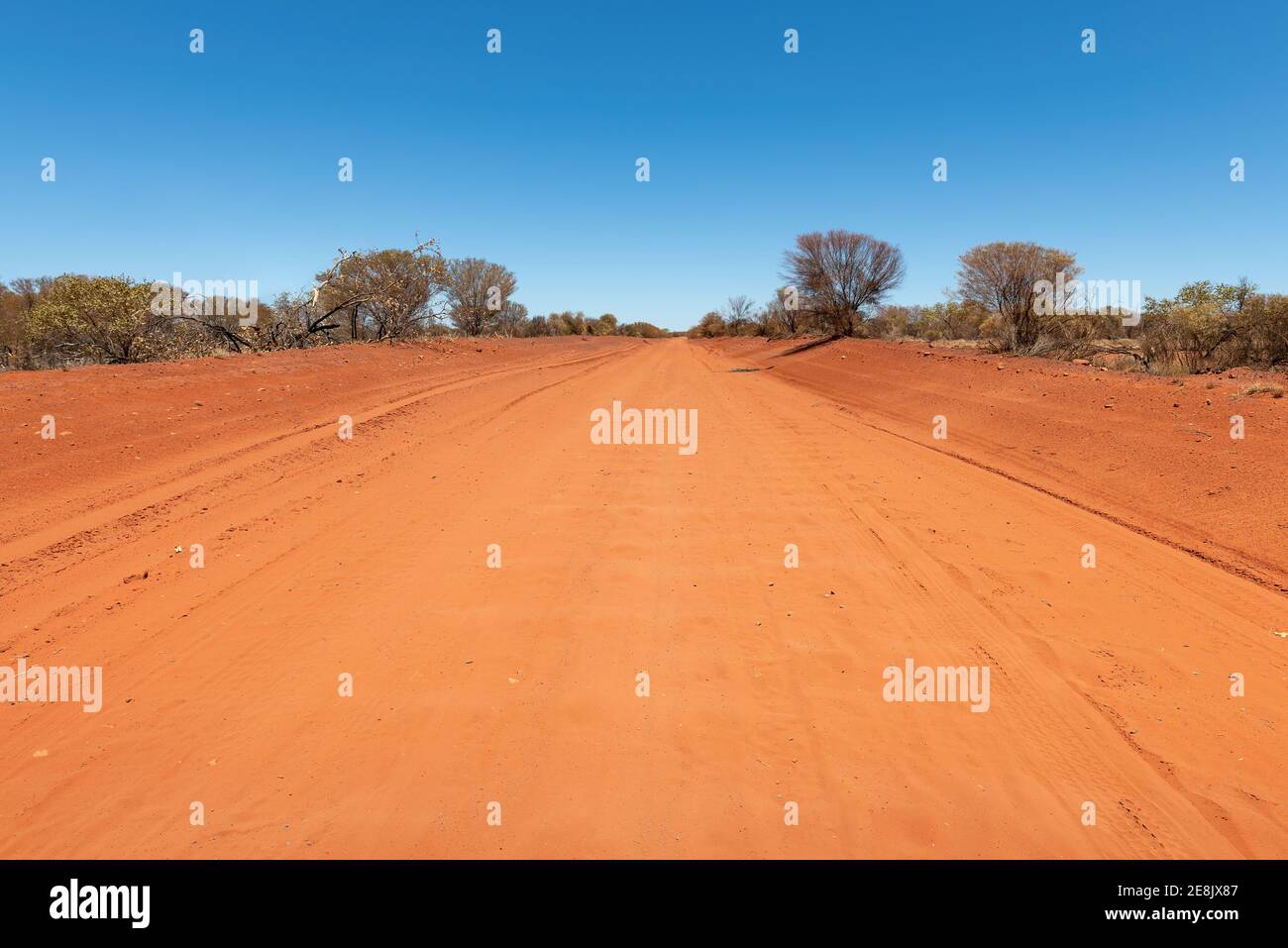 A dirt road in the red center of the Australian outback, Northern Territory, Australia. Stock Photo