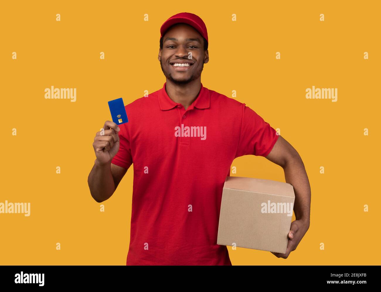 Black delivery man holding credit card and box Stock Photo
