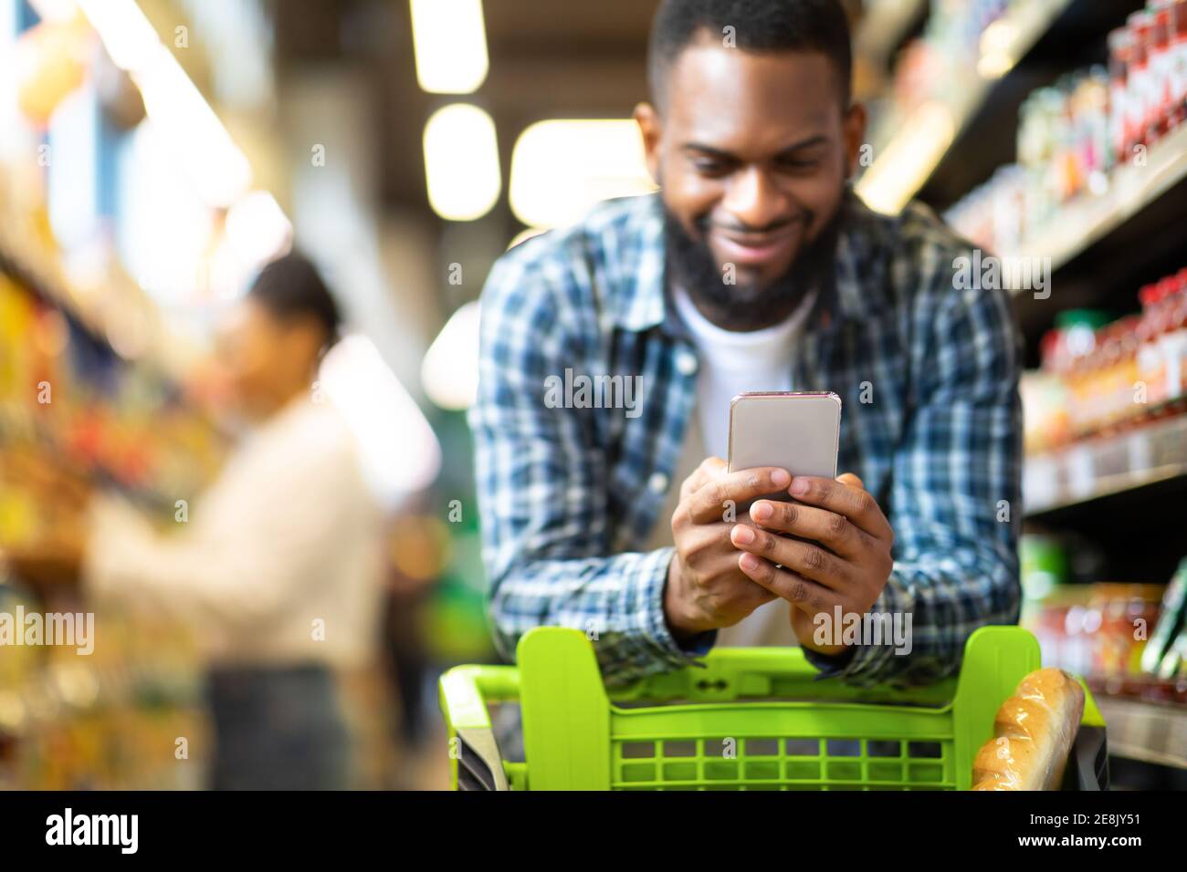 Black Man Using Coupon App For Groceries Shopping In Supermarket Stock