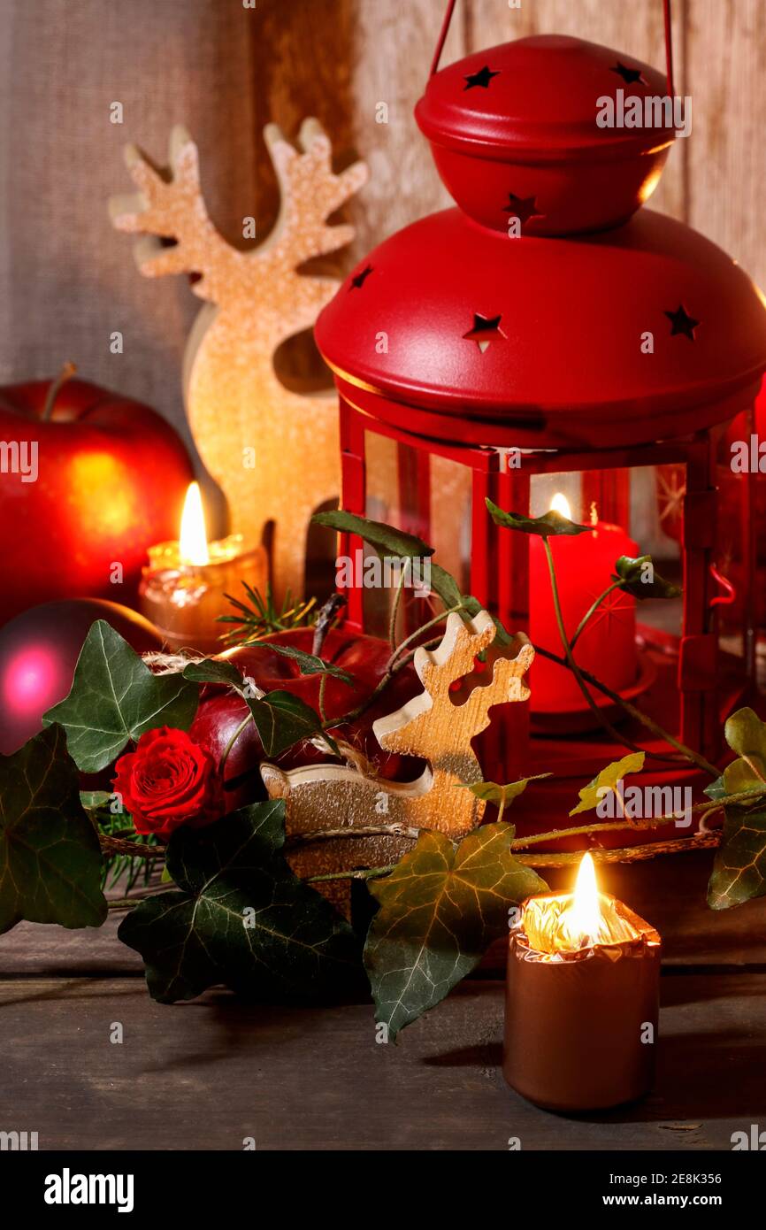 Christmas decoration with red lantern, candle, apples and ivy leaves.  Festive tima Stock Photo - Alamy