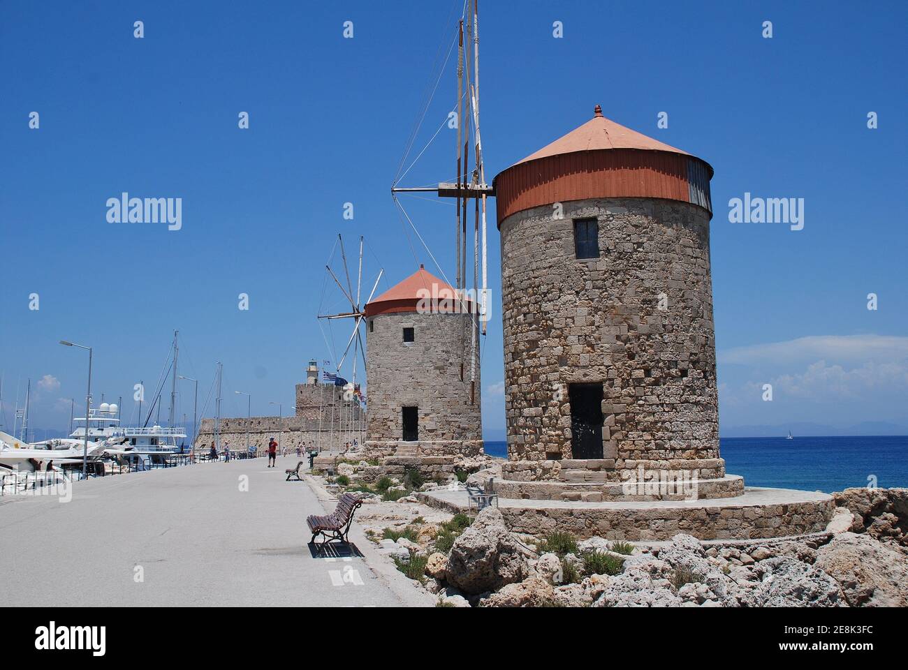 The medieval stone windmills at Mandraki harbour in the Old Town of the Greek island of Rhodes on June 9, 2019. Stock Photo