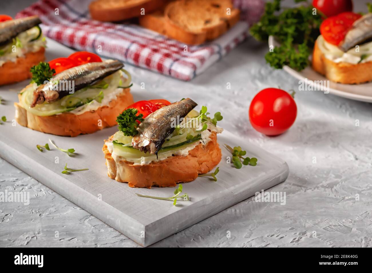 Smoked sprat sandwich fish, fresh cucumber and tomato. Sprat