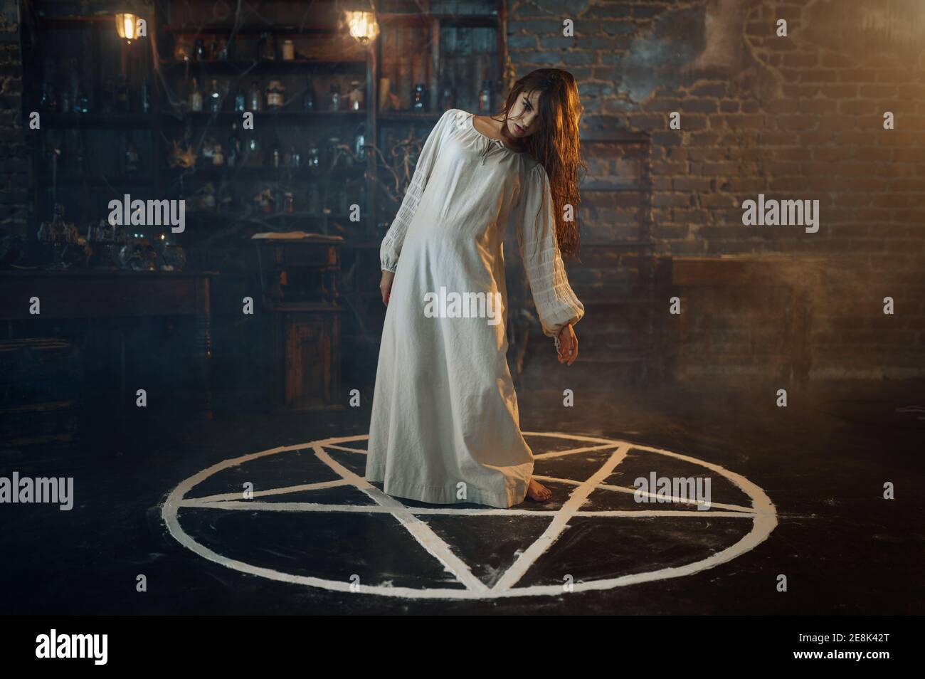Creepy demonic woman standing in the magic circle Stock Photo