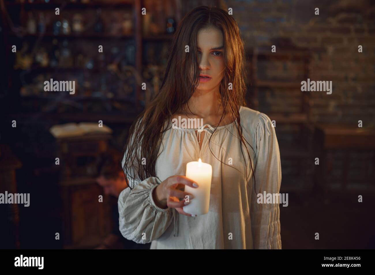 Creepy woman holds candle, demons casting out Stock Photo