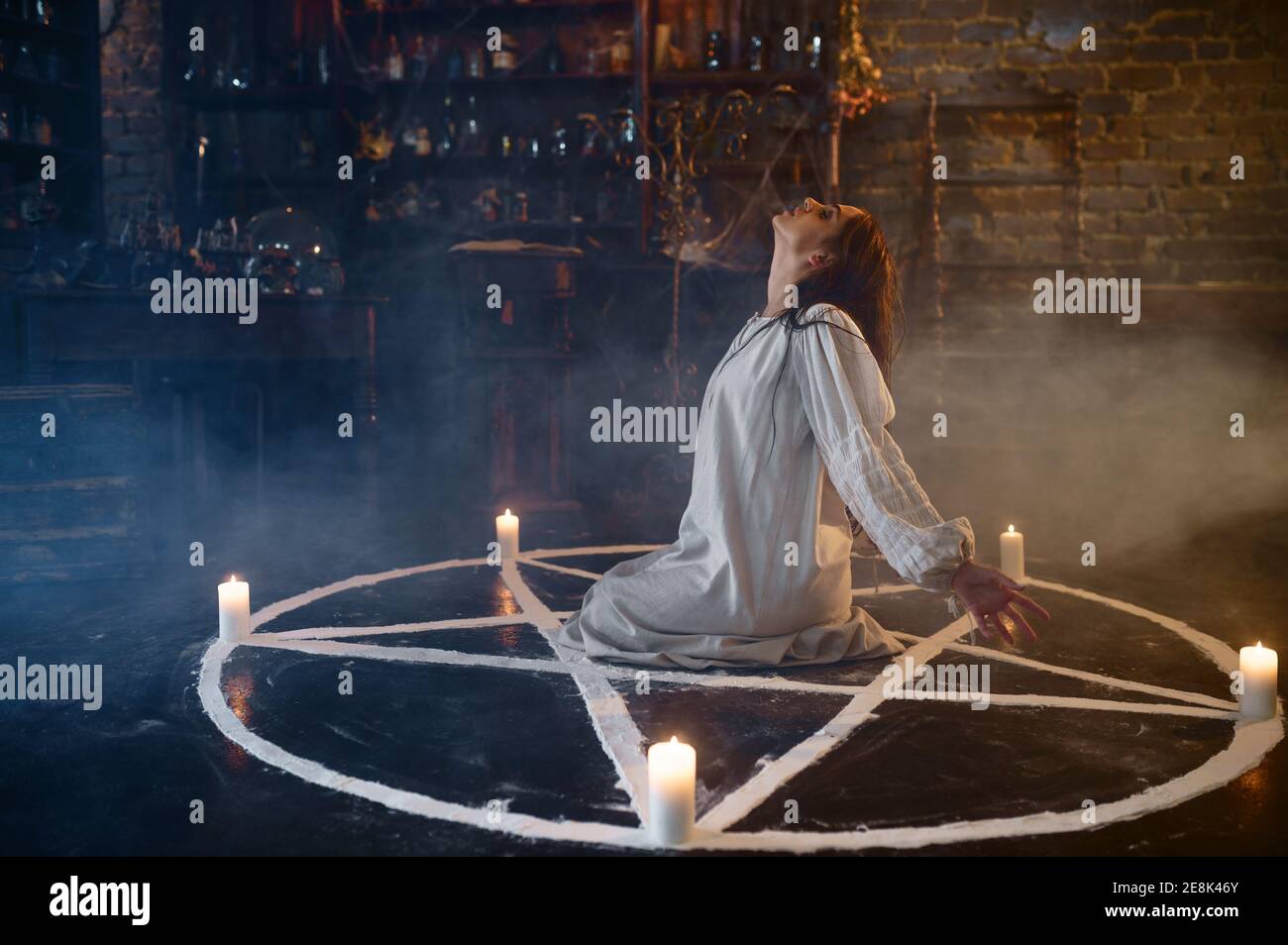 Scary demonic woman sitting in the magic circle Stock Photo