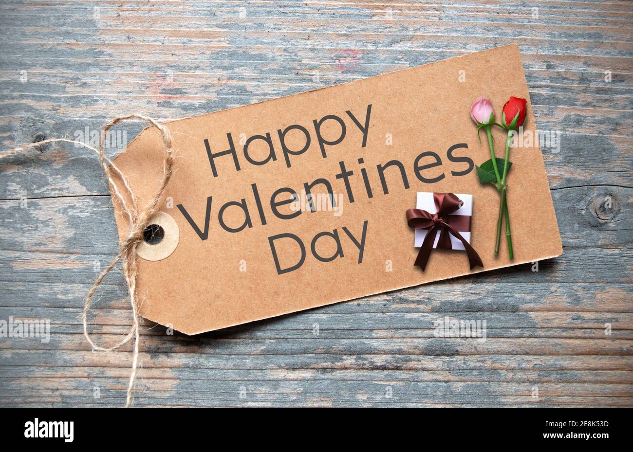 Happy valentines day handwritten on a label with two roses and wrapped ...