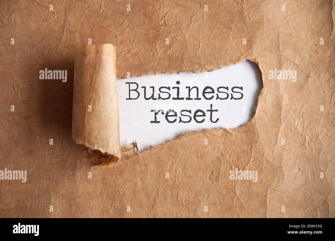 Torn piece of scroll revealing business reset Stock Photo