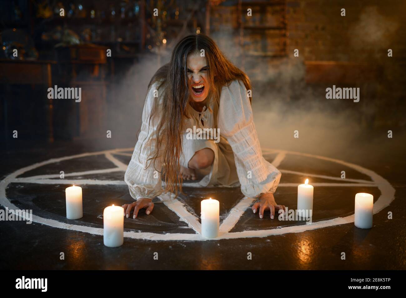 Crazy woman sitting in magic circle with candles Stock Photo