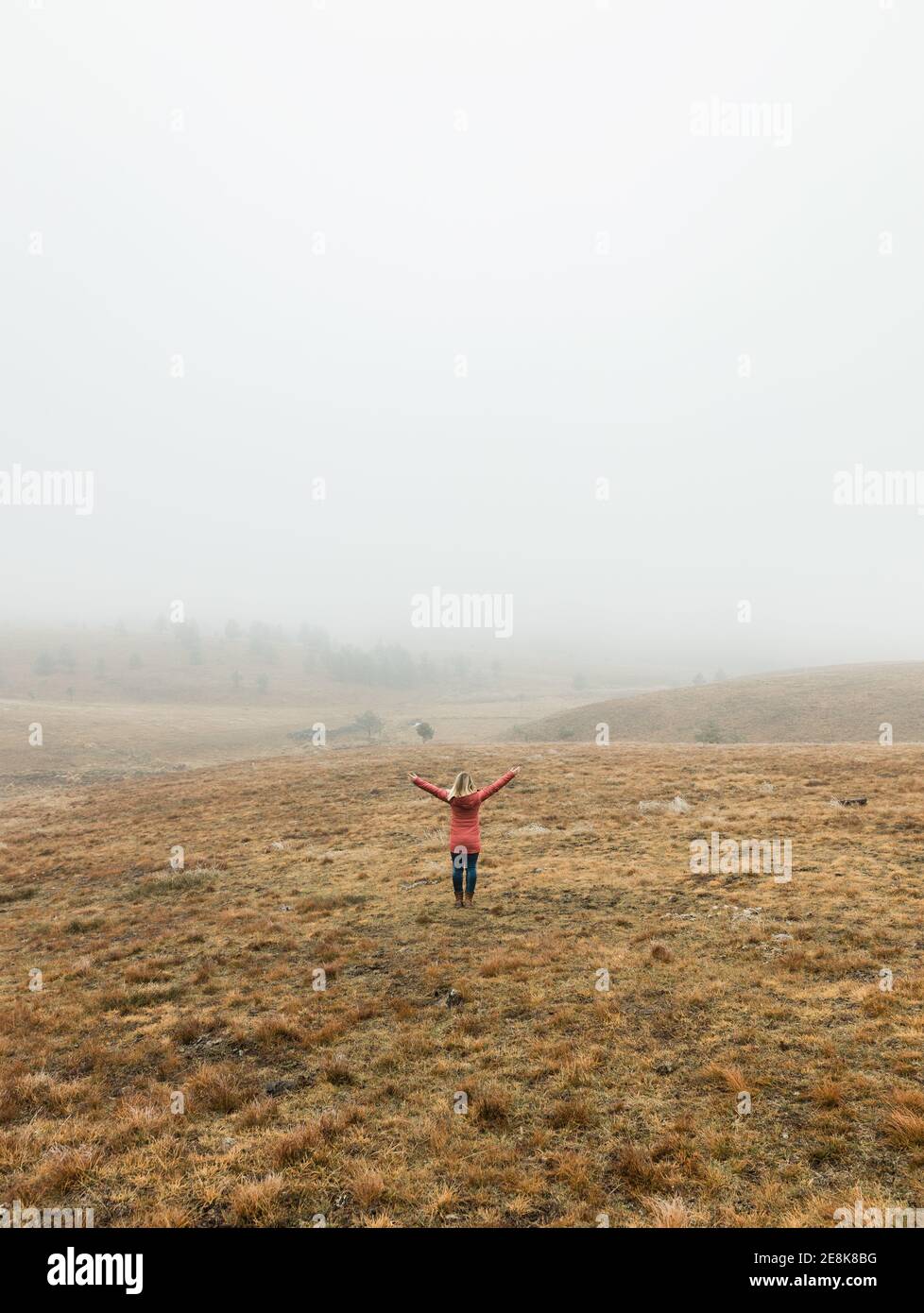 Young woman exploring nature in the foggy winter morning Stock Photo