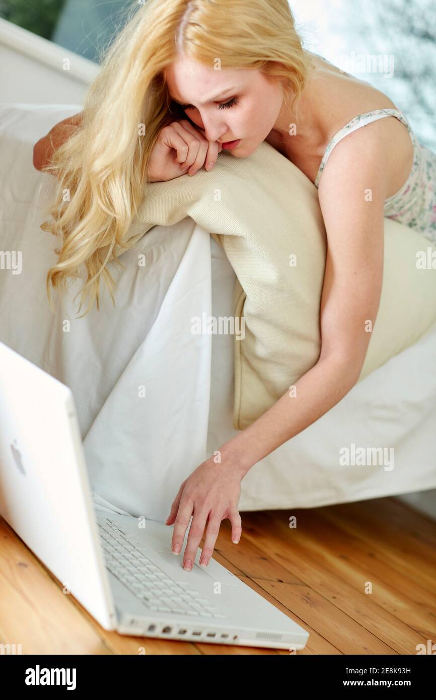 Concerned looking woman using laptop Stock Photo