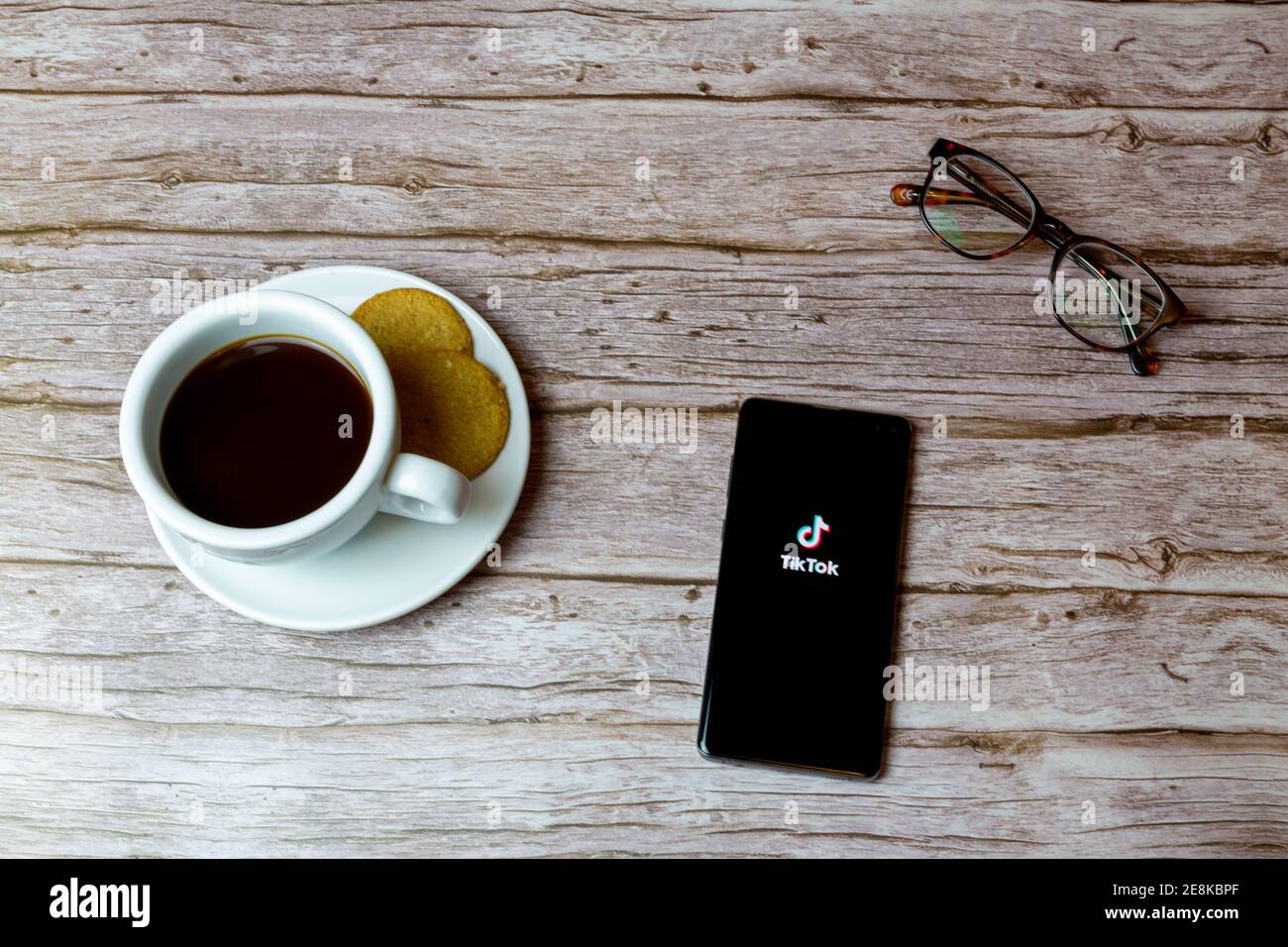 A mobile phone or cell phone laid on a table with the TikTok app open Stock Photo