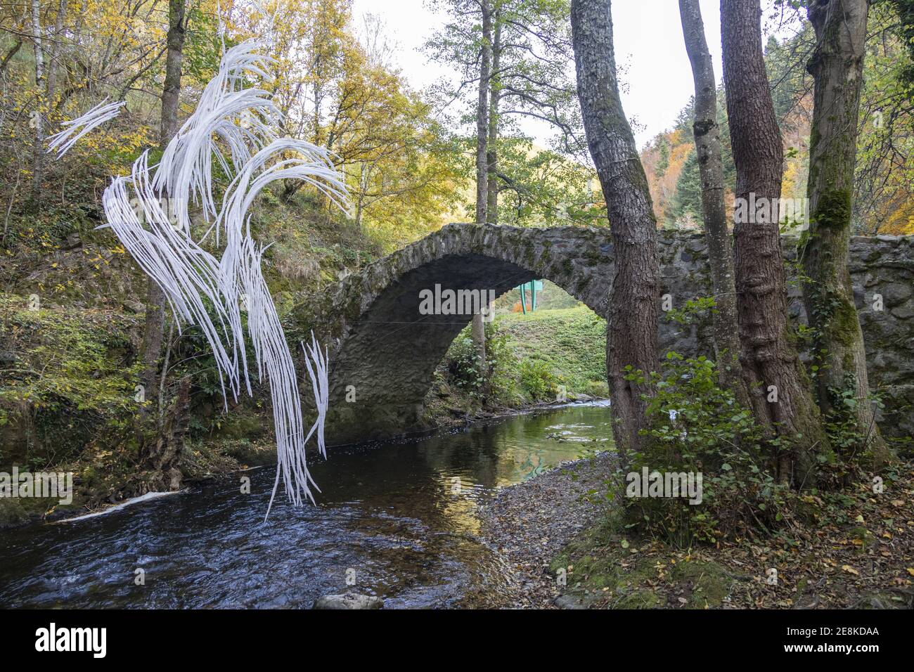 Auvergne, France. 24th Oct, 2020. Old stone bridge on the Couze Pavin with an ephemeral work of art of Anne Poinvilliers in the Gorge of Courgoul. Stock Photo