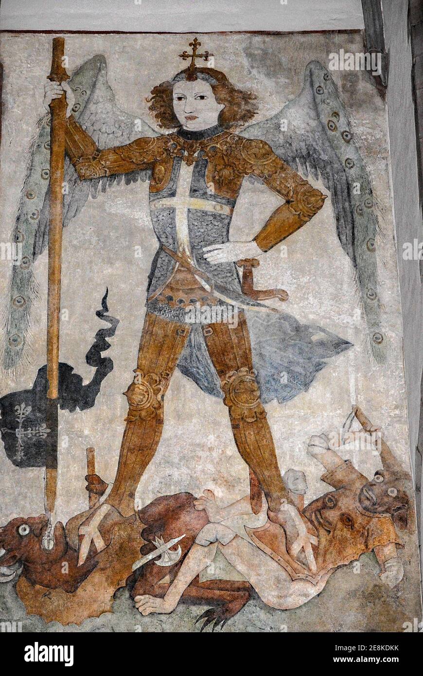 St Michael the Archangel, triumphant, crushes two demons underfoot while lancing one through the mouth.  Late Gothic 1400s fresco, attributed to German artist Jost Haller, in the Église Saint-Thomas Lutheran church in Strasbourg, Bas-Rhin, Alsace, Grand-Est, France. Stock Photo