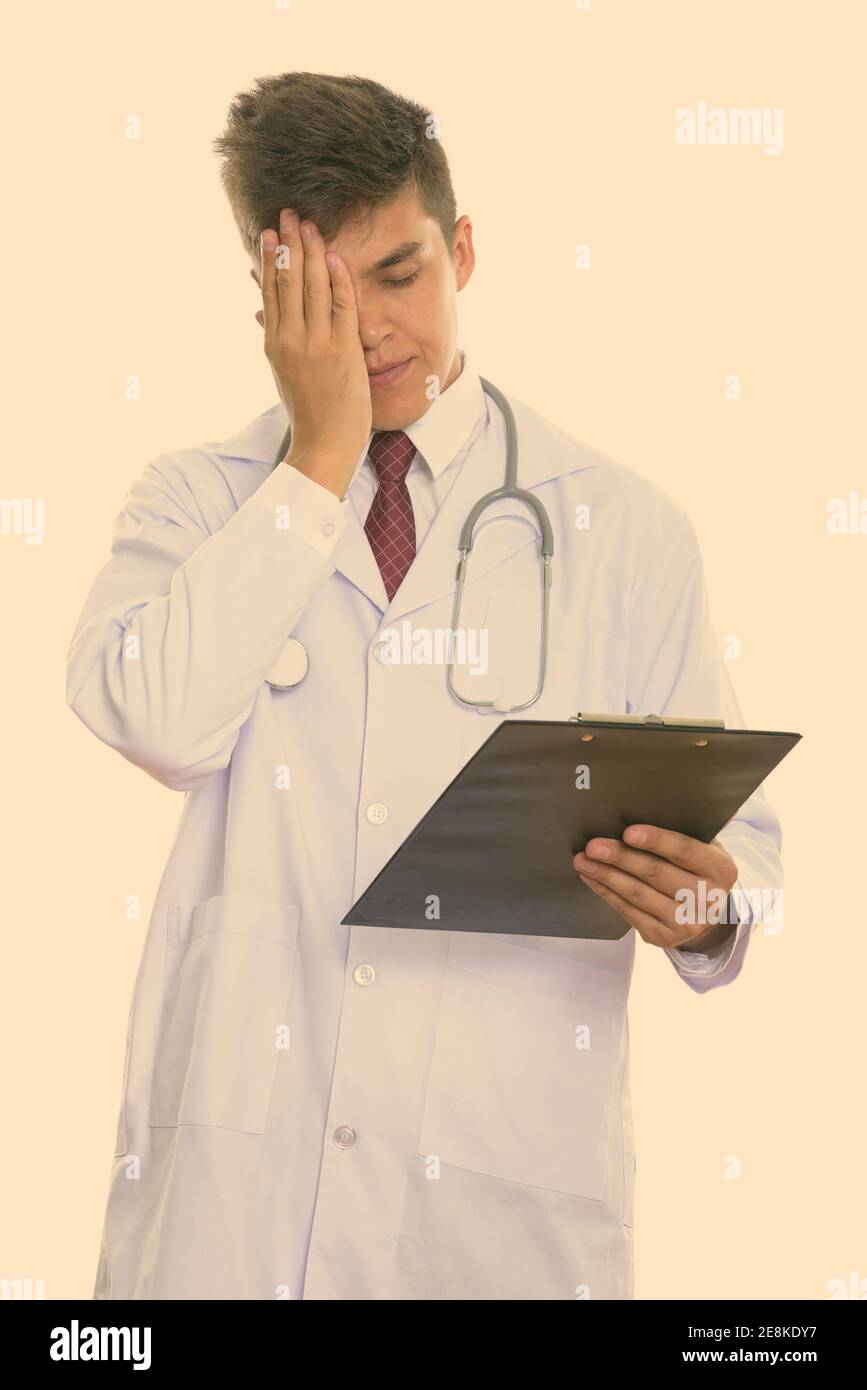 Studio shot of young stressed man doctor holding clipboard Stock Photo