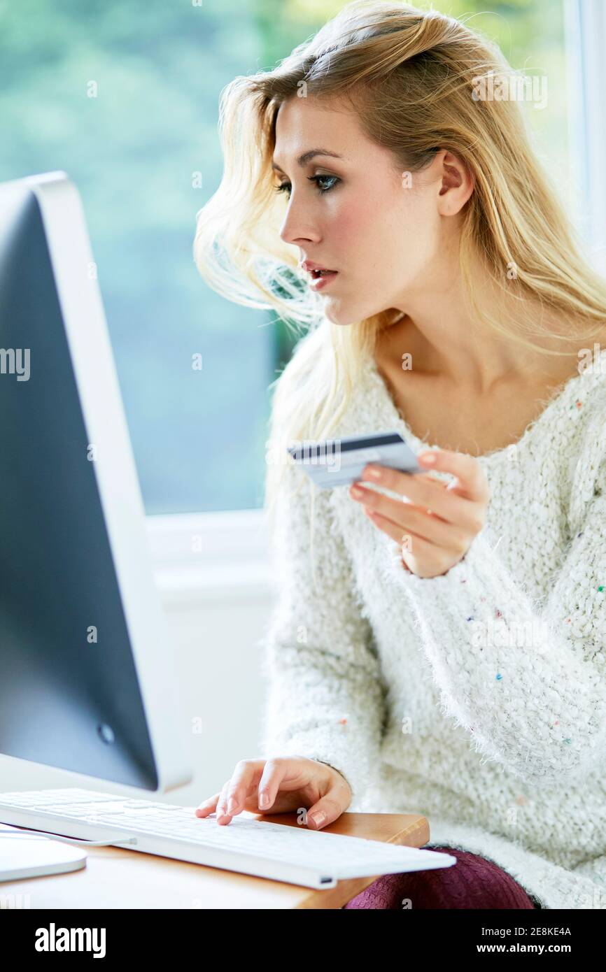 Woman holding her credit card purchasing items online Stock Photo