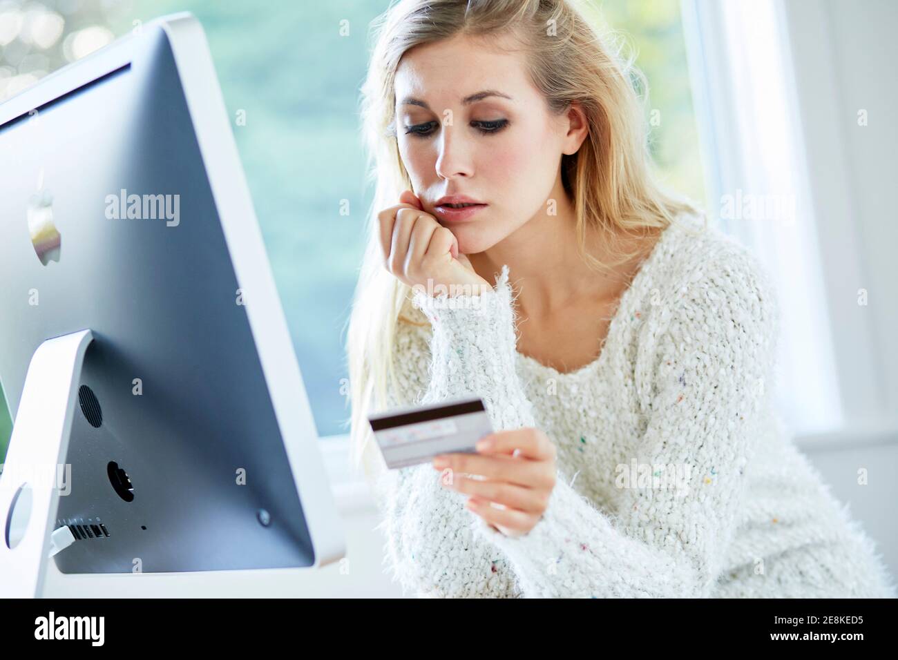 Woman holding her credit card purchasing items online Stock Photo