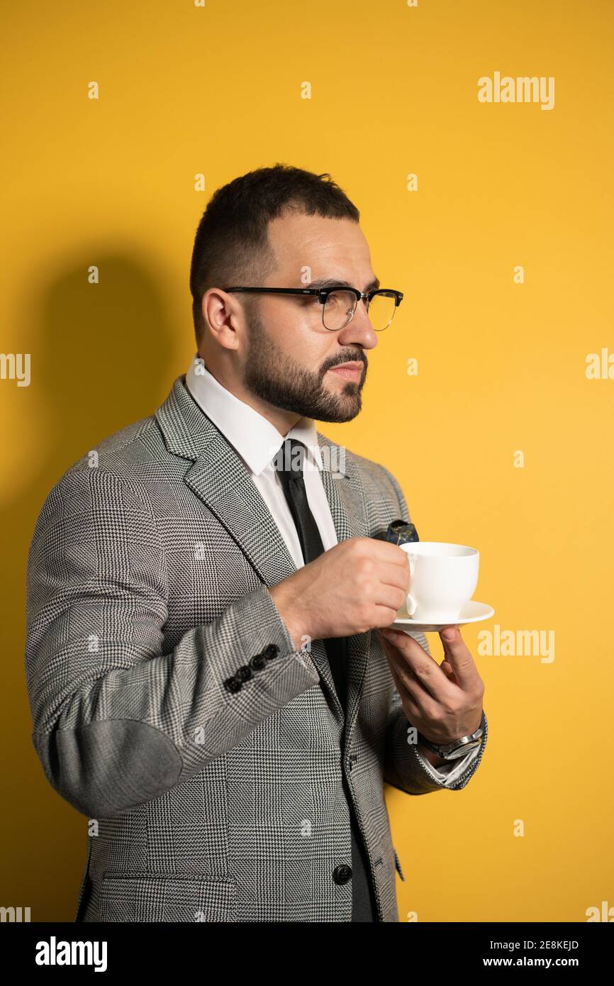 Enjoying his cup of coffee handsome young bearded business man in eye ...