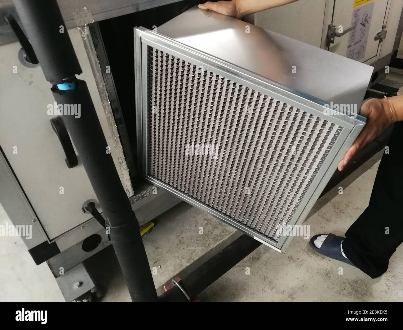 Soft Focus on Man hold a Filter of Air handing Unit, Technician checking a Medium -filter of air handling unit for replacement a new filter - HVAC mai Stock Photo