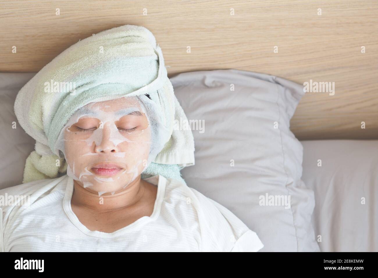 Soft focus on Asian young woman with a sheet mask on her face. - Wellness face care and Spa Concept. Stock Photo