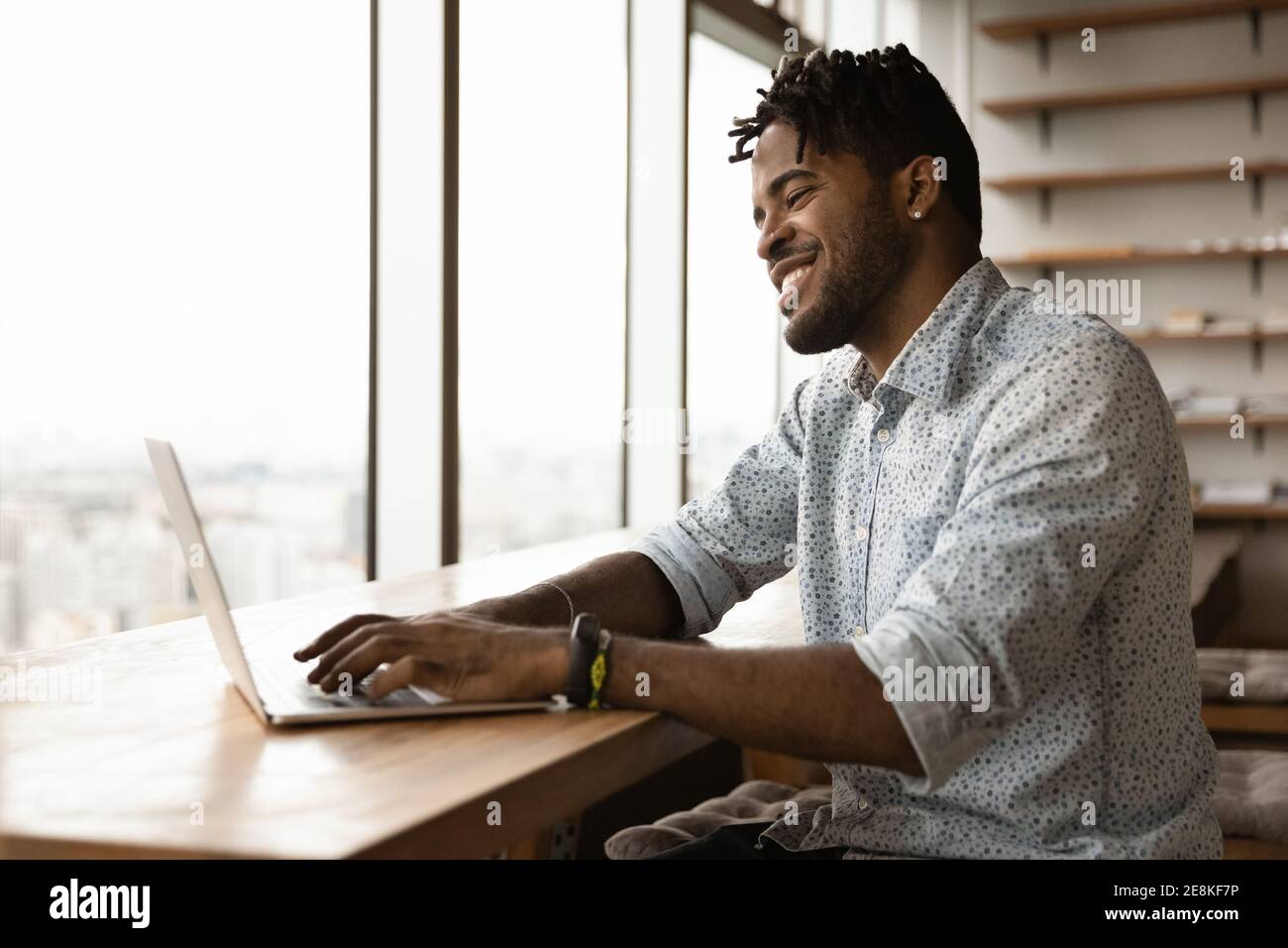 Happy young afro man playing pc video game on laptop Stock Photo